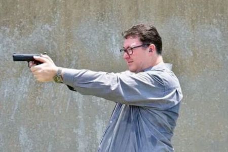 fat cunt pointing hand gun at someone