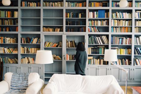 woman looking at home library book selection